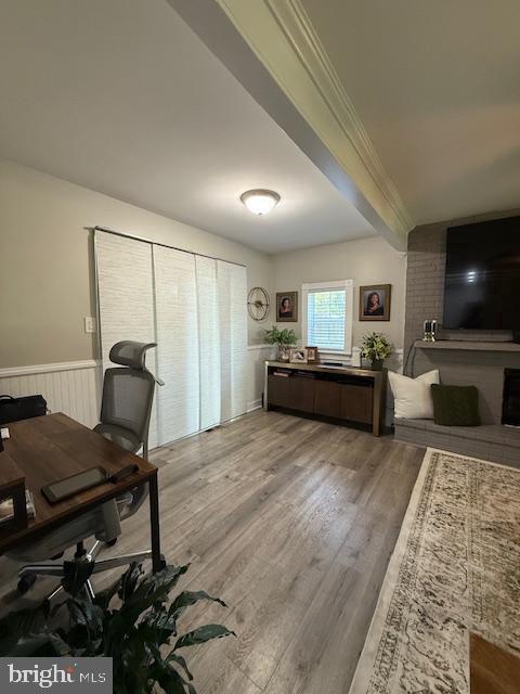 office area featuring ornamental molding, a wainscoted wall, and wood finished floors
