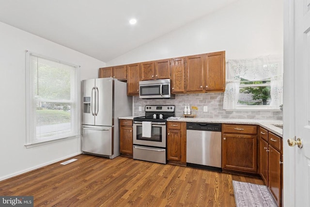 10804 Cobblestone Dr, Spotsylvania, VA 22553 - kitchen featuring stainless steel appliances, vaulted ceiling, backsplash, light countertops, and dark wood-style floors