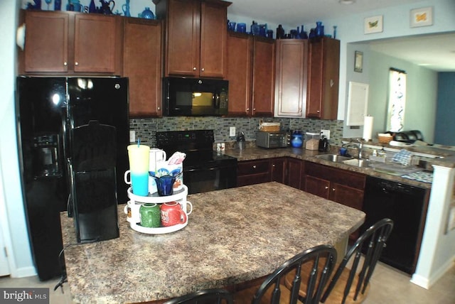  - kitchen with black appliances, decorative backsplash, a peninsula, and dark stone countertops