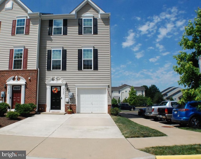  - view of front of house with brick siding, concrete driveway, and an attached garage
