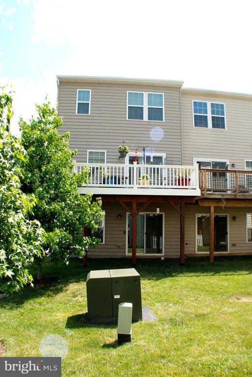  - back of house featuring a yard and a wooden deck