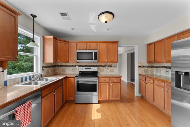 17417 Hawthorne Ave, Culpeper, VA 22701 - kitchen with appliances with stainless steel finishes, backsplash, light wood-type flooring, decorative light fixtures, and light countertops