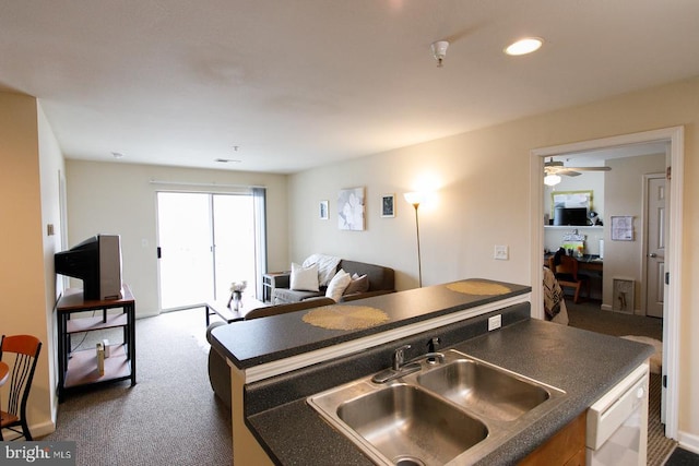 kitchen featuring a sink, dark countertops, white dishwasher, dark carpet, and open floor plan