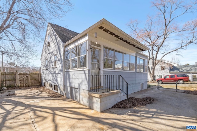 view of front of property with a sunroom, a gate, and fence