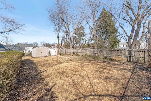 view of yard featuring an outdoor structure, a fenced backyard, and a storage unit