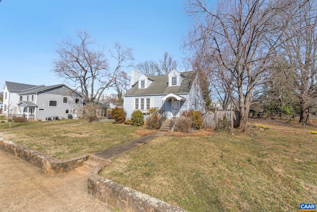 cape cod home with a chimney and a front yard