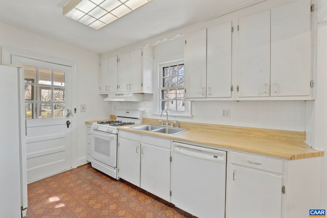 kitchen featuring under cabinet range hood, white appliances, a healthy amount of sunlight, and a sink