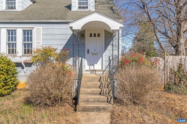 doorway to property with roof with shingles