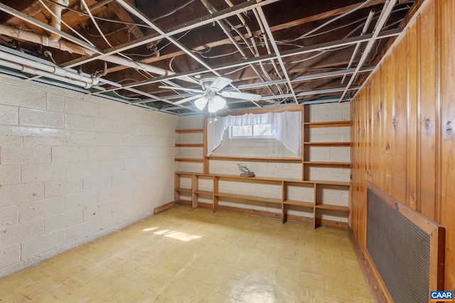basement featuring tile patterned floors, concrete block wall, and wooden walls