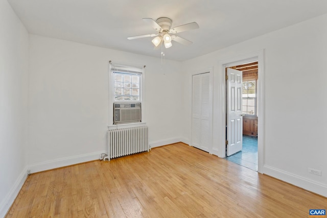 empty room with cooling unit, radiator, a ceiling fan, and a healthy amount of sunlight