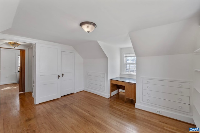 additional living space featuring lofted ceiling, baseboards, and light wood-type flooring
