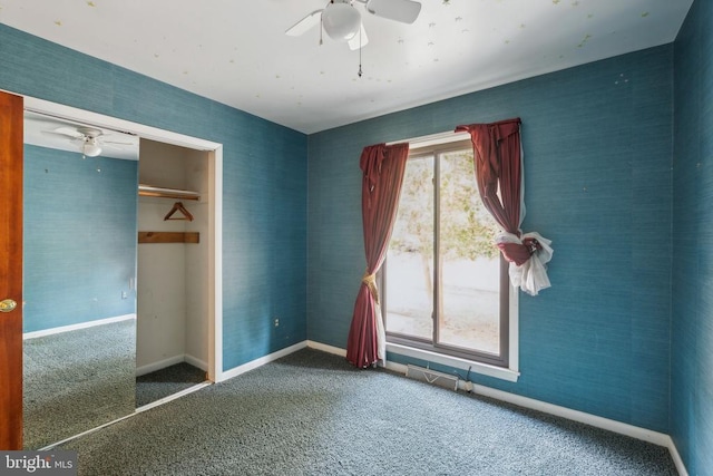 unfurnished bedroom featuring carpet floors, baseboards, ceiling fan, and a closet