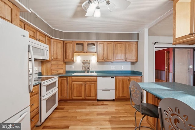 kitchen with white appliances, a sink, light wood-type flooring, a ceiling fan, and dark countertops