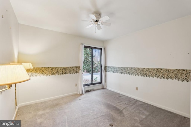 empty room featuring a ceiling fan, baseboards, and carpet