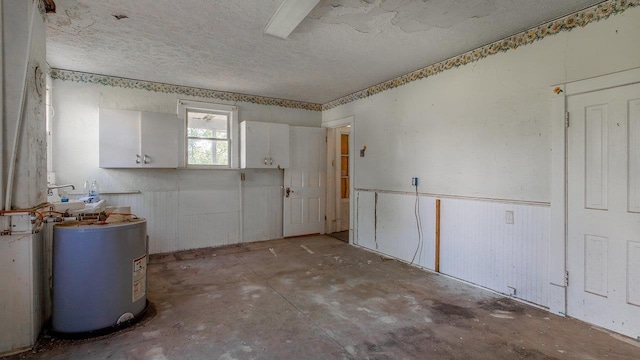 506 Williams Ave, Shenandoah, VA 22849 - spare room featuring water heater, a textured ceiling, and unfinished concrete flooring