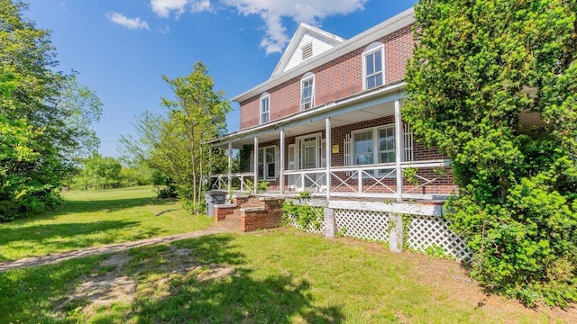 506 Williams Ave, Shenandoah, VA 22849 - view of front of house featuring covered porch, brick siding, and a front lawn