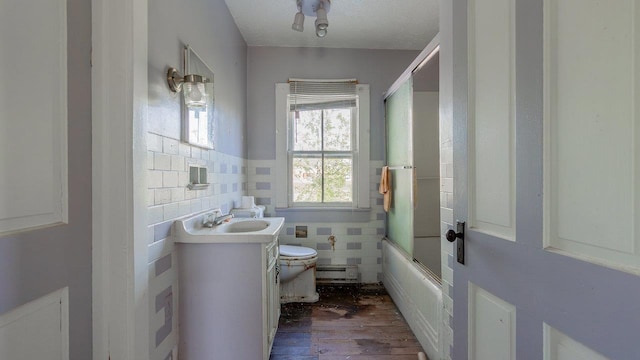 506 Williams Ave, Shenandoah, VA 22849 - bathroom featuring tile walls, toilet, wood finished floors, combined bath / shower with glass door, and vanity