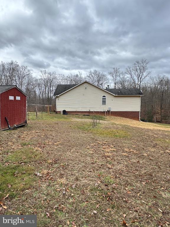 view of side of home with a storage unit and an outdoor structure
