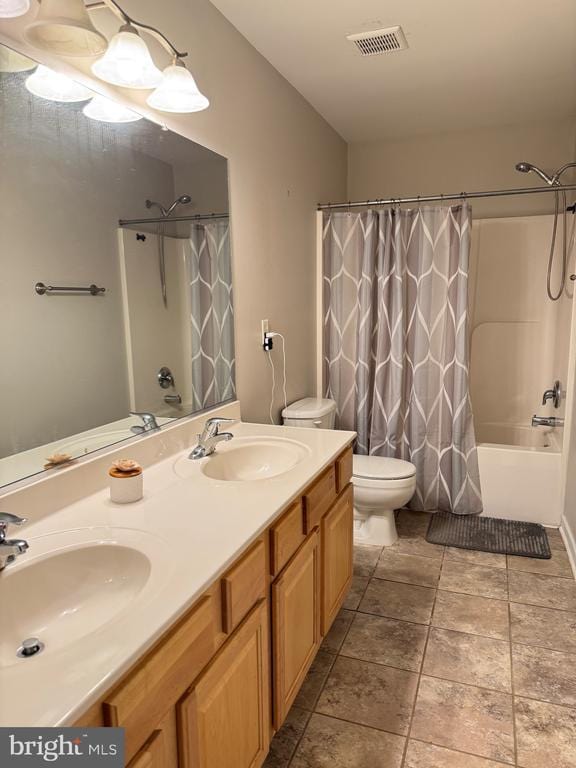 bathroom featuring toilet, double vanity, and shower / bath combo with shower curtain