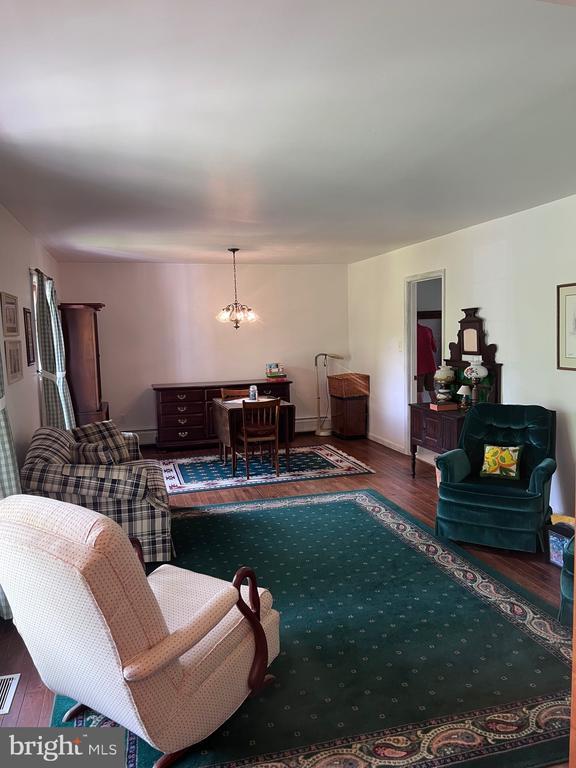  - living room featuring wood finished floors and a chandelier