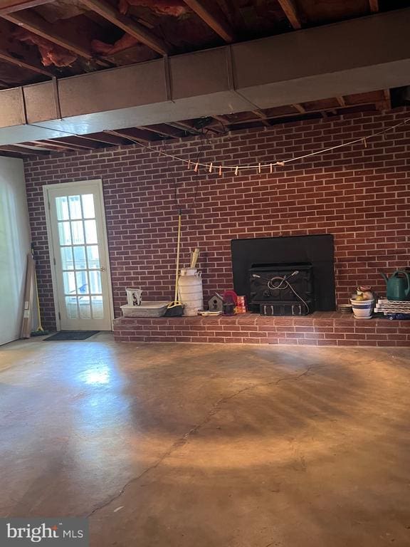  - living area with concrete floors, brick wall, and a wood stove