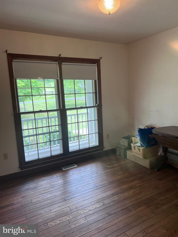 - unfurnished room featuring healthy amount of natural light and hardwood / wood-style floors