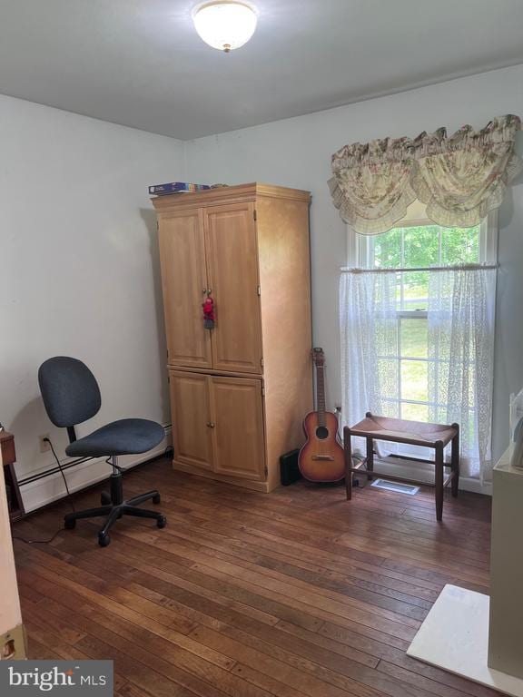  - office space with dark wood-style flooring and a baseboard heating unit