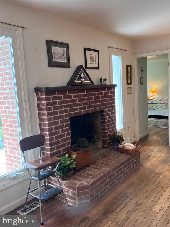  - living room featuring hardwood / wood-style floors, a brick fireplace, and healthy amount of natural light