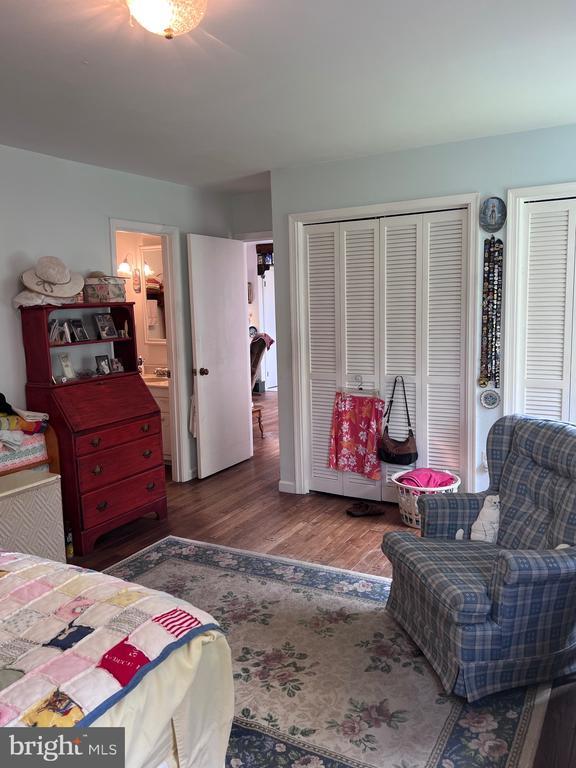  - bedroom with wood finished floors and multiple closets