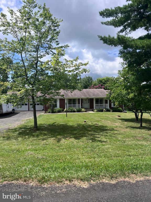  - view of front of house with a porch, an attached garage, a front lawn, and driveway
