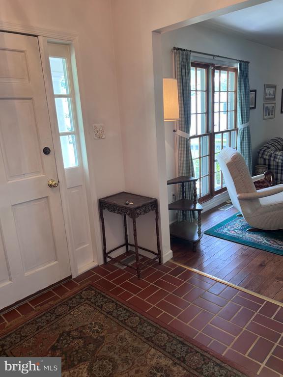  - entrance foyer featuring brick patterned flooring and baseboards