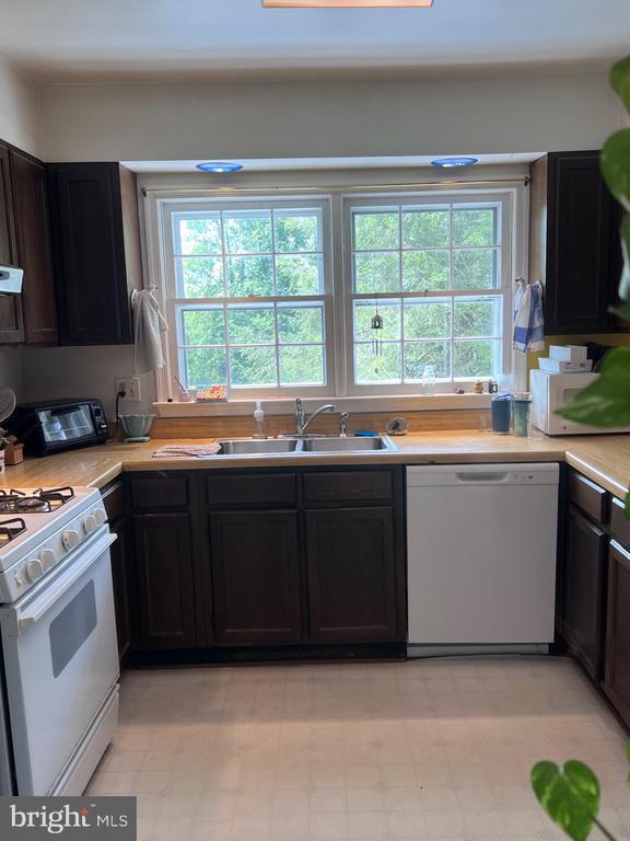  - kitchen with white appliances, healthy amount of natural light, and light countertops