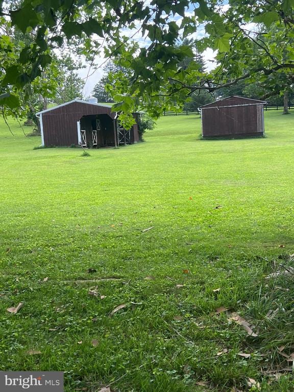  - view of green lawn featuring an outdoor structure and a pole building
