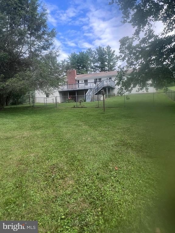  - view of yard featuring a wooden deck and stairway