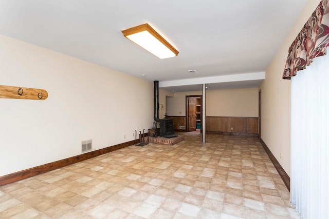 812 Meadowbrook Rd, Waynesboro, VA 22980 - basement with a wood stove, wood walls, baseboards, and a wainscoted wall