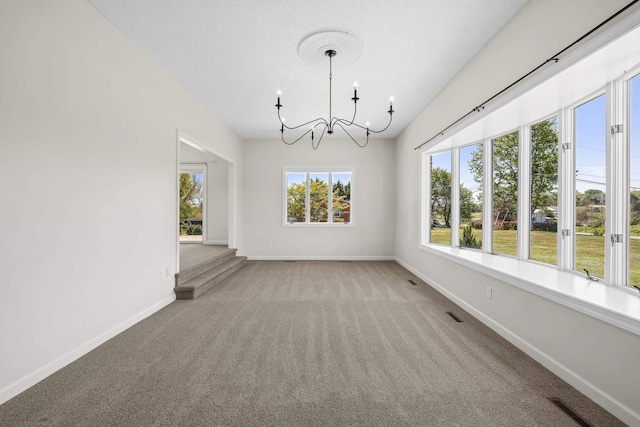 unfurnished dining area featuring a chandelier, carpet, and baseboards