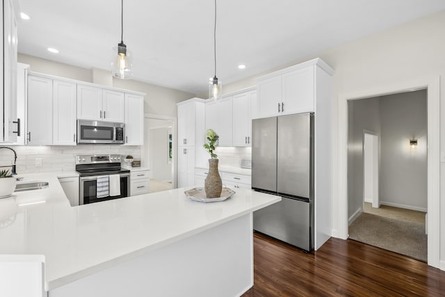 kitchen with stainless steel appliances, a sink, decorative backsplash, a peninsula, and light countertops