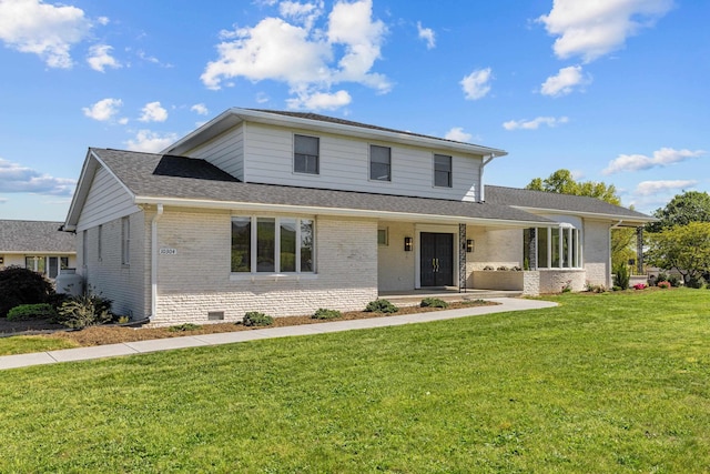 traditional-style home with brick siding, a front yard, a shingled roof, a porch, and crawl space