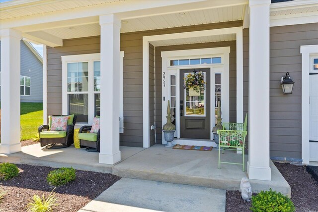 view of exterior entry featuring covered porch