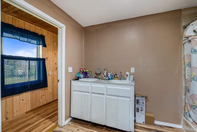 2015 Cecil Wampler Rd, Rockingham, VA 22841 - bar featuring a sink, light wood-type flooring, baseboards, and wood walls