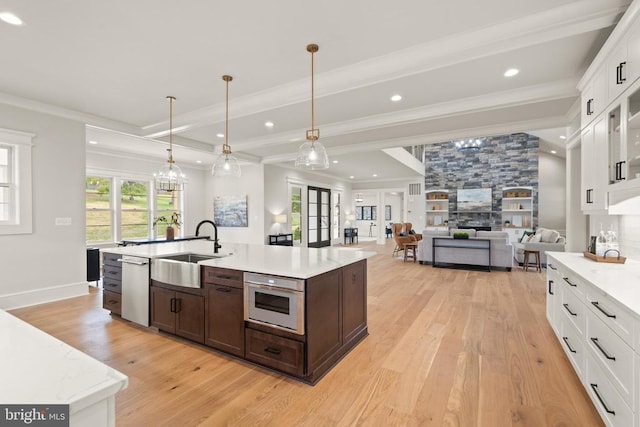  - kitchen featuring a sink, dark brown cabinets, light wood-style flooring, white cabinets, and crown molding