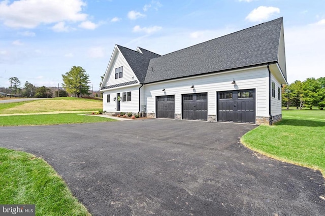  - view of property exterior with a lawn, asphalt driveway, a shingled roof, and a garage