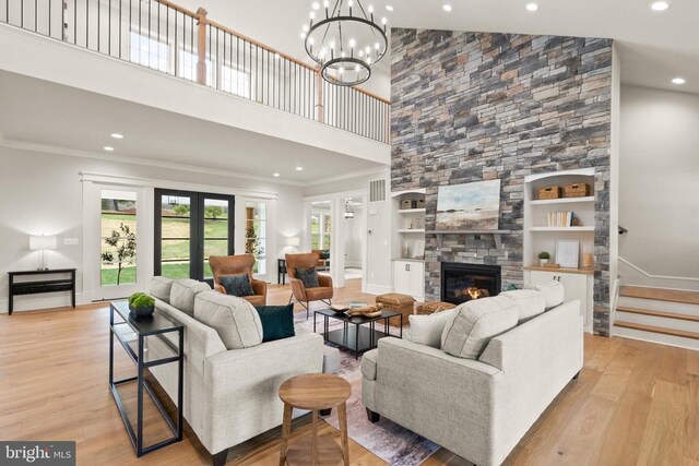  - living area featuring a high ceiling, wood finished floors, recessed lighting, a fireplace, and crown molding