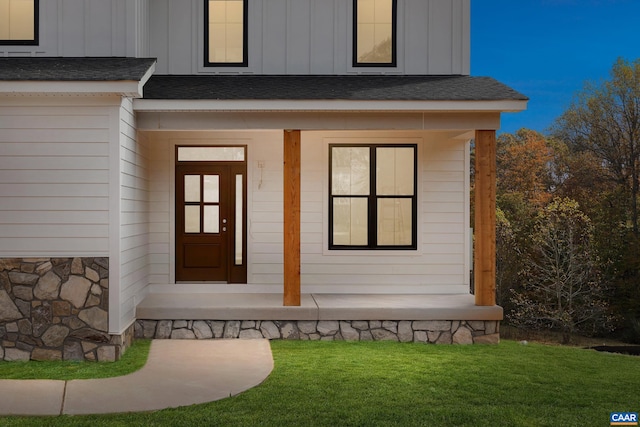 121 Yates Cir, Stanardsville, VA 22973 - view of exterior entry with a yard, a shingled roof, covered porch, and board and batten siding