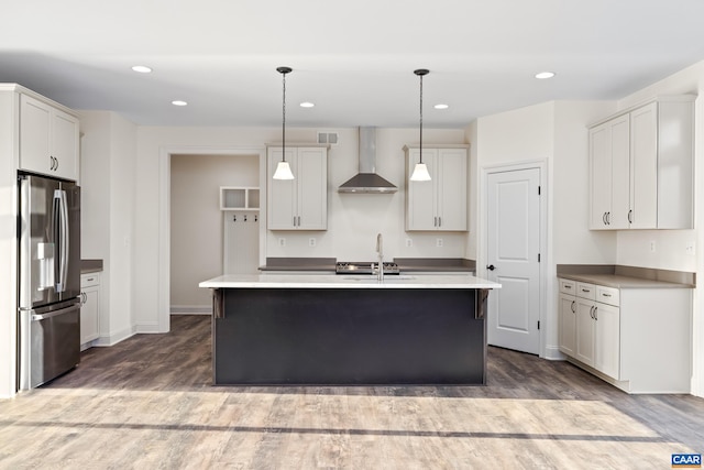 121 Yates Cir, Stanardsville, VA 22973 - kitchen with recessed lighting, wood finished floors, stainless steel fridge, and wall chimney exhaust hood