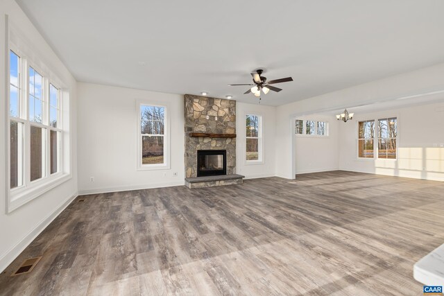 121 Yates Cir, Stanardsville, VA 22973 - unfurnished living room featuring baseboards, a stone fireplace, visible vents, ceiling fan with notable chandelier, and wood finished floors