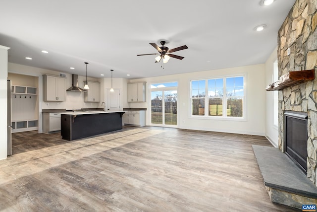 121 Yates Cir, Stanardsville, VA 22973 - unfurnished living room with light wood-style flooring, recessed lighting, baseboards, a stone fireplace, and ceiling fan