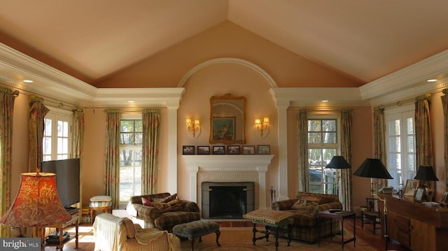  - sitting room with a fireplace, vaulted ceiling, ornamental molding, and wood finished floors