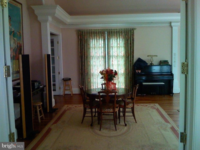  - dining room with crown molding, wood finished floors, and ornate columns