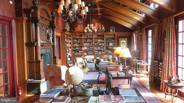  - living area with a chandelier, high vaulted ceiling, and wood finished floors